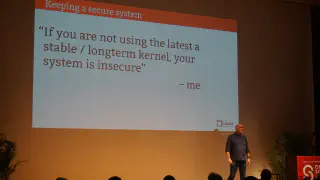 Greg Kroah-Hartman on stage in-front of a slide quoting himself as saying &ldquo;If you are not using the latest stable / long-term kernel, your system is insecure&rdquo;